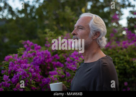 Senior man having coffee in balcony Stock Photo
