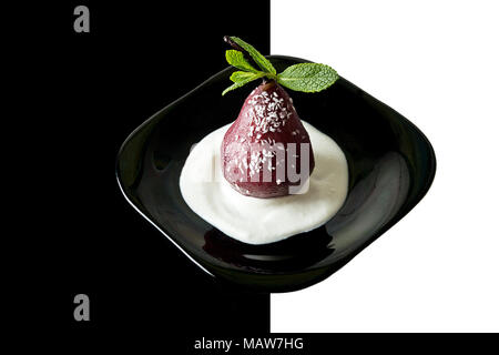 Pears in wine. Traditional dessert pears stewed in red wine with whipped cream on plate on white black  background. Copy space Stock Photo