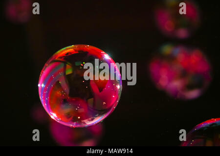 Abstract image of soap bubbles from the bubble blower in dark. Stock Photo