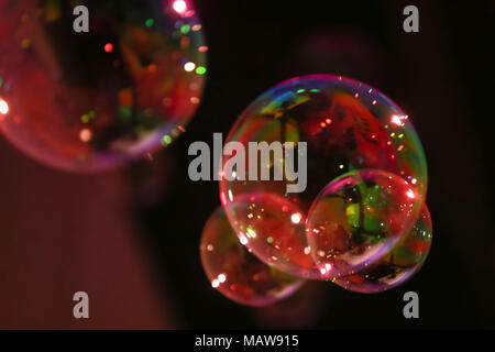 Abstract image of soap bubbles from the bubble blower in dark. Stock Photo