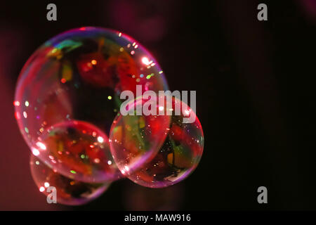 Abstract image of soap bubbles from the bubble blower in dark. Stock Photo