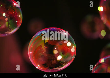 Abstract image of soap bubbles from the bubble blower in dark. Stock Photo