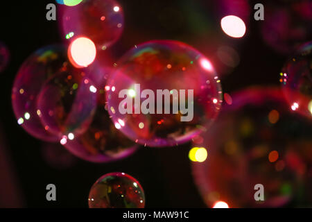 Abstract image of soap bubbles from the bubble blower in dark. Stock Photo