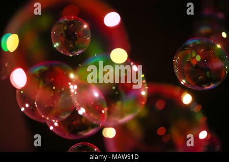 Abstract image of soap bubbles from the bubble blower in dark. Stock Photo