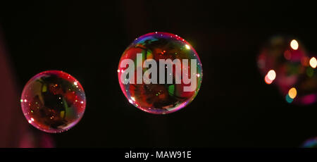 Abstract image of soap bubbles from the bubble blower in dark. Stock Photo