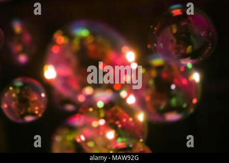 Abstract image of soap bubbles from the bubble blower in dark. Stock Photo