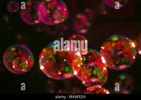 Abstract image of soap bubbles from the bubble blower in dark. Stock Photo