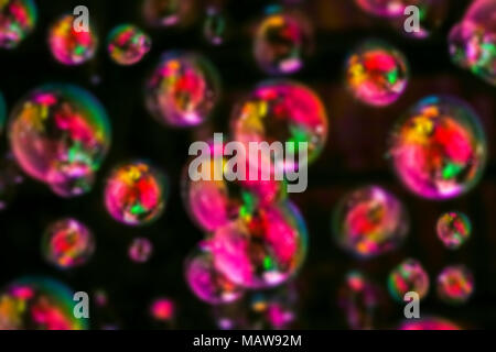 Abstract image of soap bubbles from the bubble blower in dark. Stock Photo