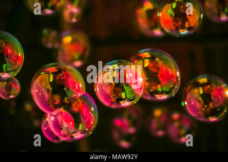 Abstract image of soap bubbles from the bubble blower in dark. Stock Photo