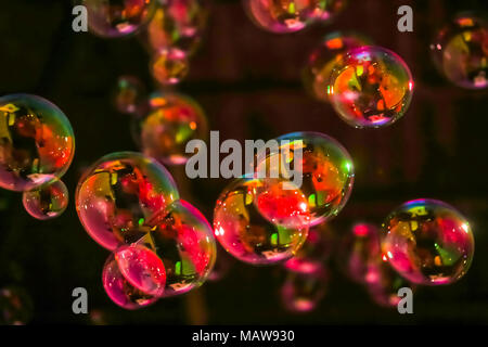 Abstract image of soap bubbles from the bubble blower in dark. Stock Photo