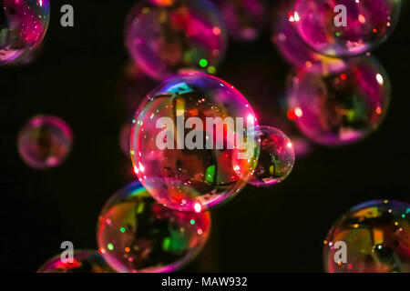 Abstract image of soap bubbles from the bubble blower in dark. Stock Photo