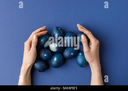 cropped image of woman touching blue painted easter eggs Stock Photo