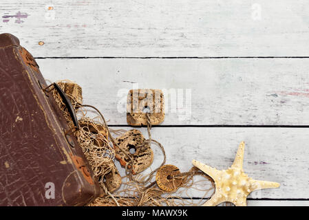 Fishing net or fisher net and white planks. Maritime background with starfish and wooden background with copy space. Stock Photo