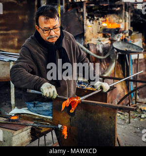 Glass blower forming beautiful piece of glass, Murano, Venice, Italy Stock Photo