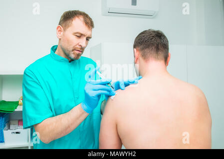Neurolis Injection Neurologist doctor makes an injection therapy, blockade into trapezium ...