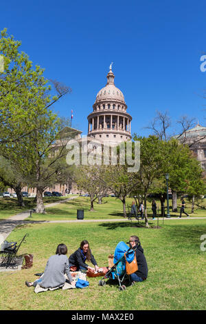 People having a picnic on the lawns on a sunny spring day, Texas State Capitol building, Austin Texas, United States of America Stock Photo