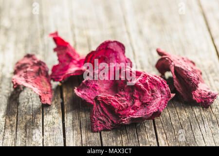 Dried beetroot chips on old wooden table. Stock Photo