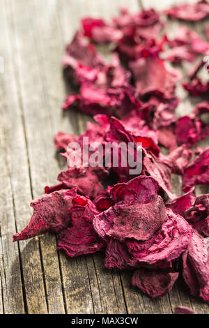 Dried beetroot chips on old wooden table. Stock Photo