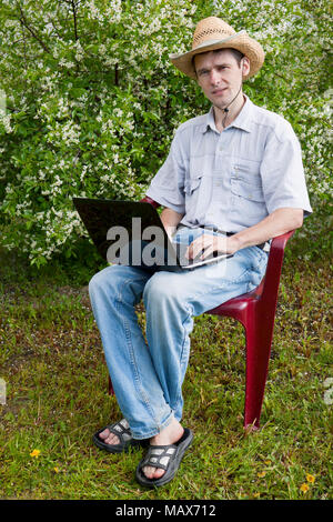 A young man in a cherry garden in spring Stock Photo