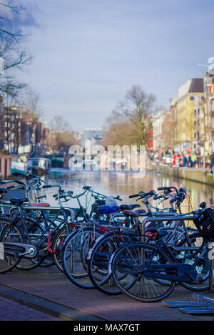 AMSTERDAM, NETHERLANDS, MARCH, 27, 2018: Outdoor view of bycicles parked at the bridge in Amsterdam Stock Photo