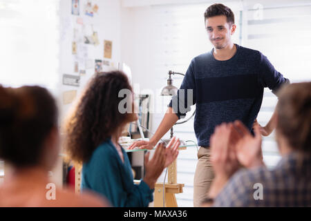 in meeting. A young man presenting his project. he is applauded Stock Photo