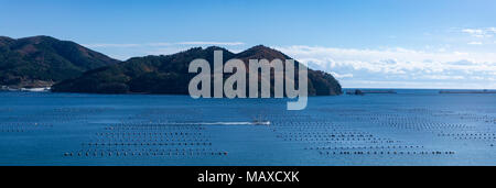 Ofunato Bay in Iwate Prefecture, Japan, with a fishing boat moving through oyster farms. This area was devastated by the tsunami in 2011. Stock Photo