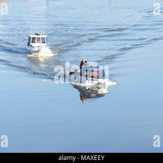 Two small motor boats moving slowly on still waters