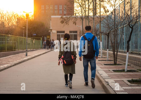 Two Chinese students Walking Side by Side on  University Campus in Xi'an, China March 2018 Stock Photo