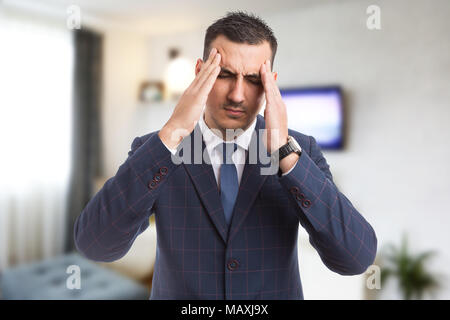 Real estate agent or realtor feeling strong migraine massaging pressing temples as overwhelming and stressful job Stock Photo