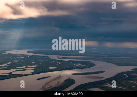 Rain comes from thunderclouds over the Great plain river in summer, the top view Stock Photo