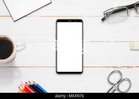 Hero header image on work desk with modern smart phone with isolated display for mockup, app, web site presentation. Flat lay, top view. Stock Photo