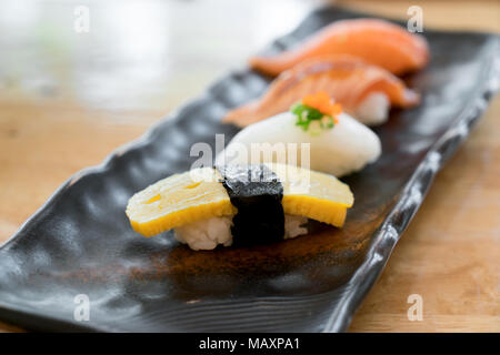 Close up of japanese cuisines nigiri sushi set on black plate served in japanese food restaurant. Stock Photo