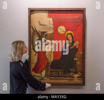 Bonhams, New Bond Street, London, UK. 5 April 2018. The international auction house, Bonhams is to sell the private art collection of the celebrated sculptor and artist, Antón Casamor. The Contents of a Catalonian Villa sale will take place in London on Wednesday 11 April. Photo: Bonhams staff hang The Annunciation, attributed to Francisco de Comontes (Spanish, active 1524-1565), estimate £20,000-30,000. Credit: Malcolm Park/Alamy Live News. Stock Photo