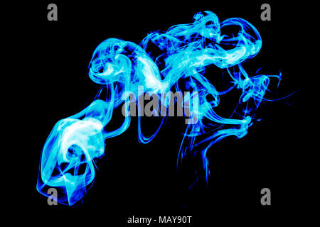 Dense blue smoke on a black isolated background. Background of smoke vape Stock Photo