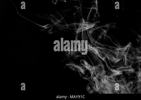 Cloud of white smoke on a black isolated background. Background from the smoke of vape Stock Photo