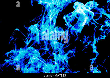 Dense blue smoke on a black isolated background. Background of smoke vape Stock Photo