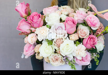 Beautiful blonde young woman holding big delicate bouquet of flowers roses carnation in rustic style Stock Photo