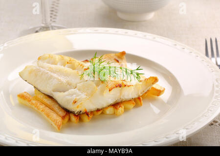 Fried cod fillet on a white plate and french fries Stock Photo