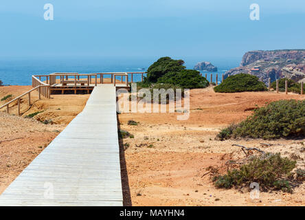 Wooden path and observation deck on summer Atlantic rocky coast (Costa Vicentina, Algarve, Portugal). Stock Photo