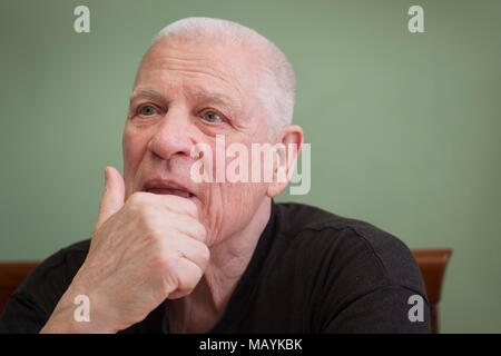 Dreamily or pensive looking senior man posing with a hand holding his head Stock Photo