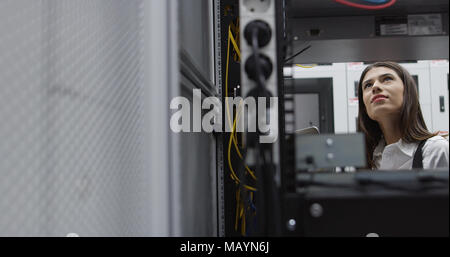 Technicians using laptop while analyzing server in server room Stock Photo