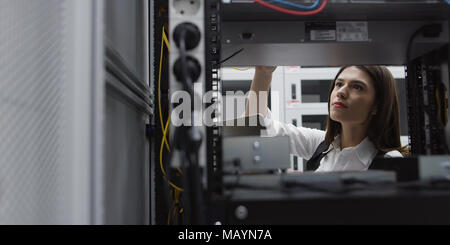 Technician performing maintenance tasks in a server room rack Stock Photo