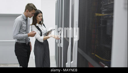 Technicians using laptop while analyzing server in server room Stock Photo