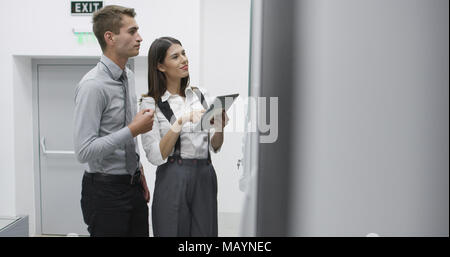 Technicians using laptop while analyzing server in server room Stock Photo