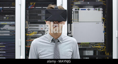 young IT engeneer using virtual reality headset over server room background Stock Photo