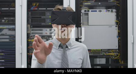 young IT engeneer using virtual reality headset over server room background Stock Photo