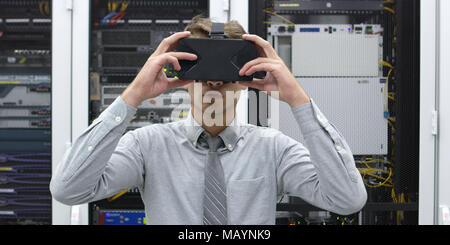 young IT engeneer using virtual reality headset over server room background Stock Photo