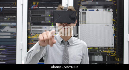 young IT engeneer using virtual reality headset over server room background Stock Photo