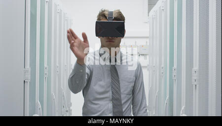 young IT engeneer using virtual reality headset over server room background Stock Photo