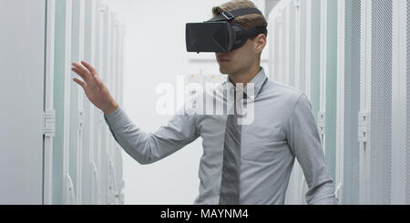 young IT engeneer using virtual reality headset over server room background Stock Photo